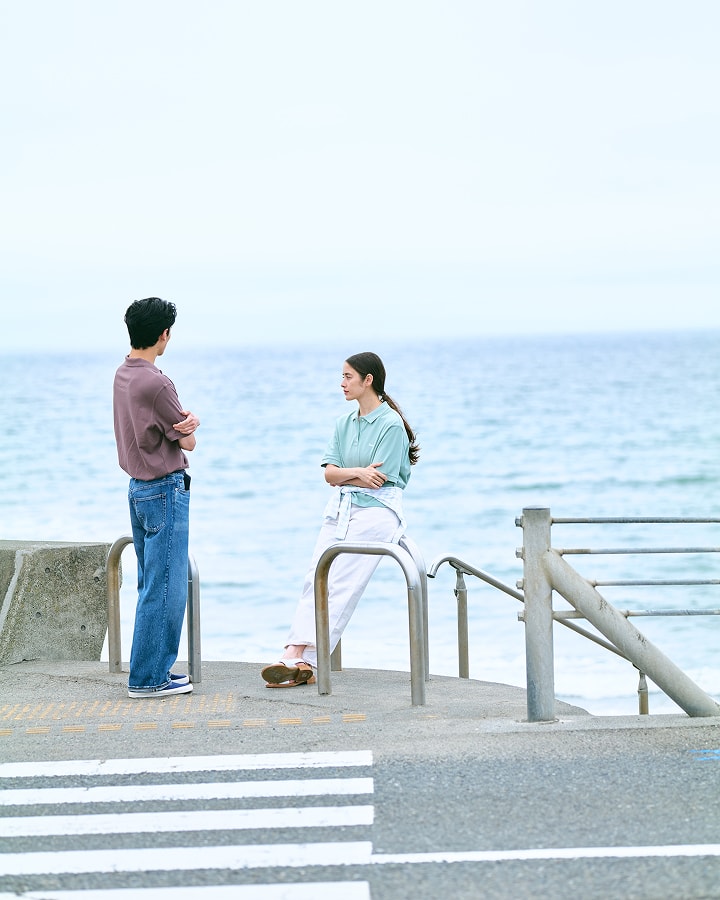 海辺で女性と男性が黄昏ている画像